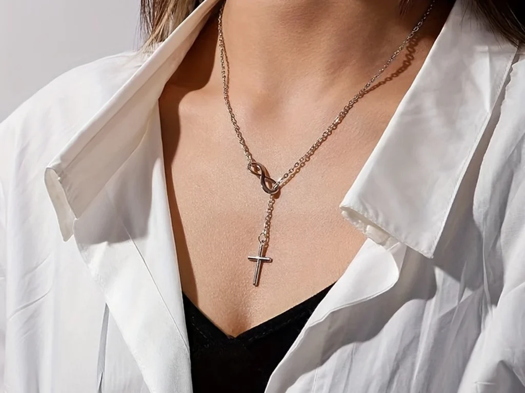 Silver-tone infinity cross necklace worn on a model