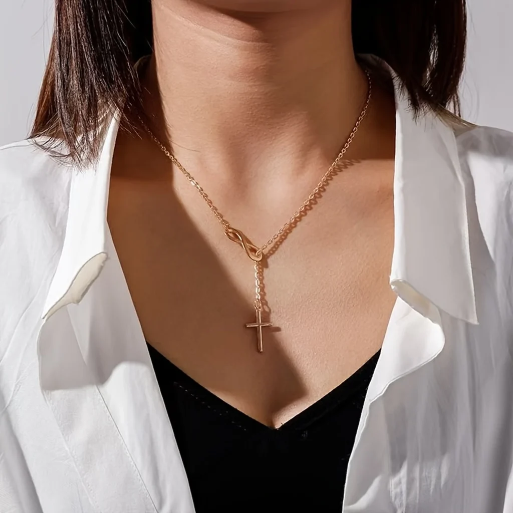 Gold-tone infinity cross necklace worn on a model