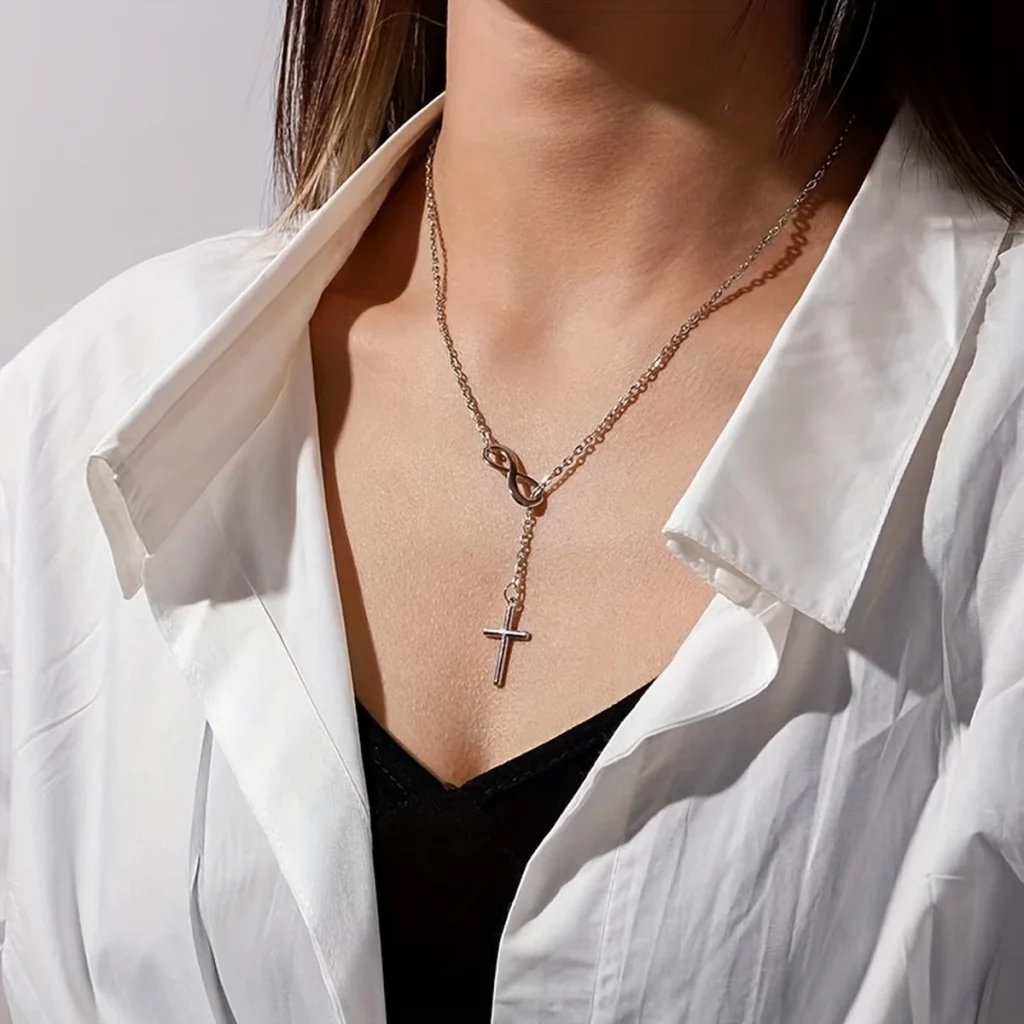 Silver-tone infinity cross necklace worn on a model