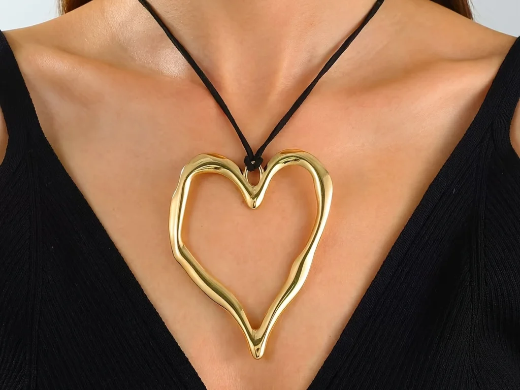Gold-tone open heart pendant necklace worn on a model