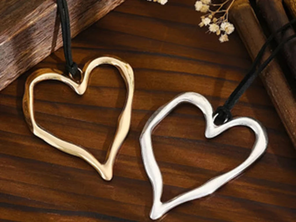 Gold-tone and silver-tone heart pendants arranged on wood
