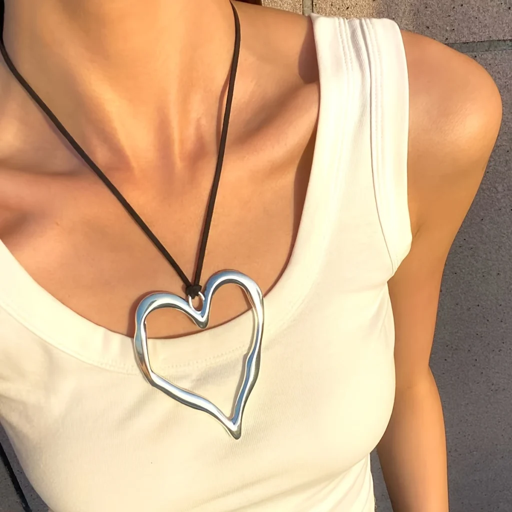 Silver-tone open heart pendant necklace worn on a model
