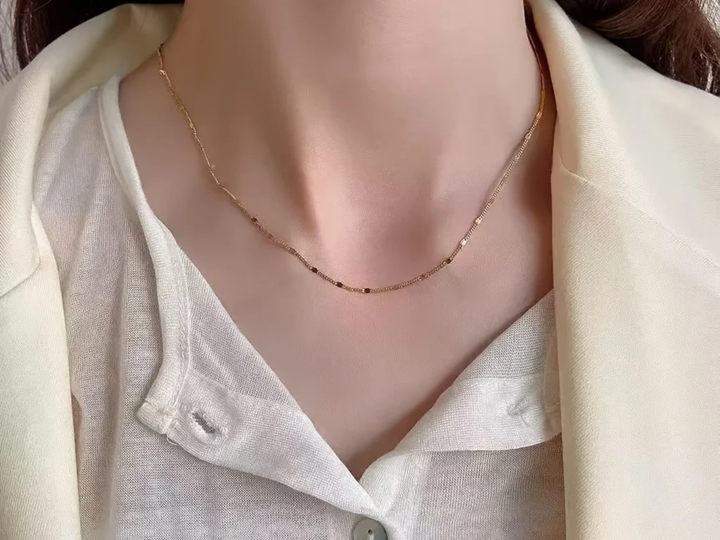 Gold-tone station necklace styled on a model