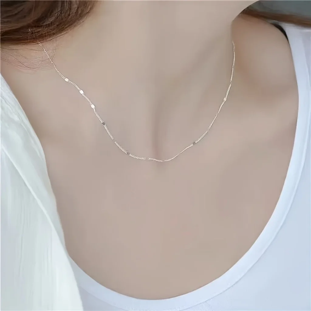 Silver-tone station chain necklace worn on a model