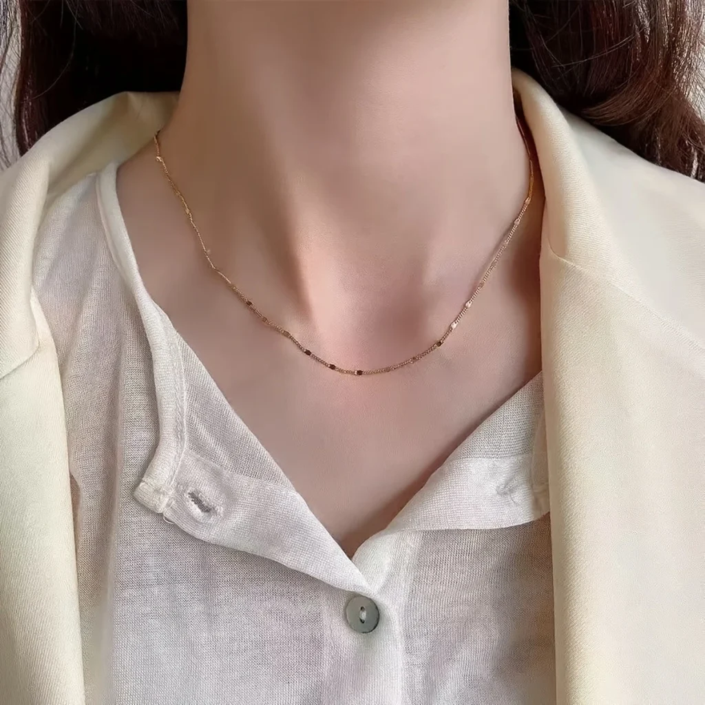 Minimalist gold-tone station necklace worn close to the neck