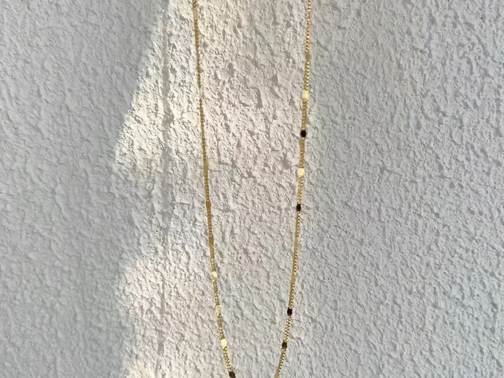 Long gold-tone station necklace hanging view