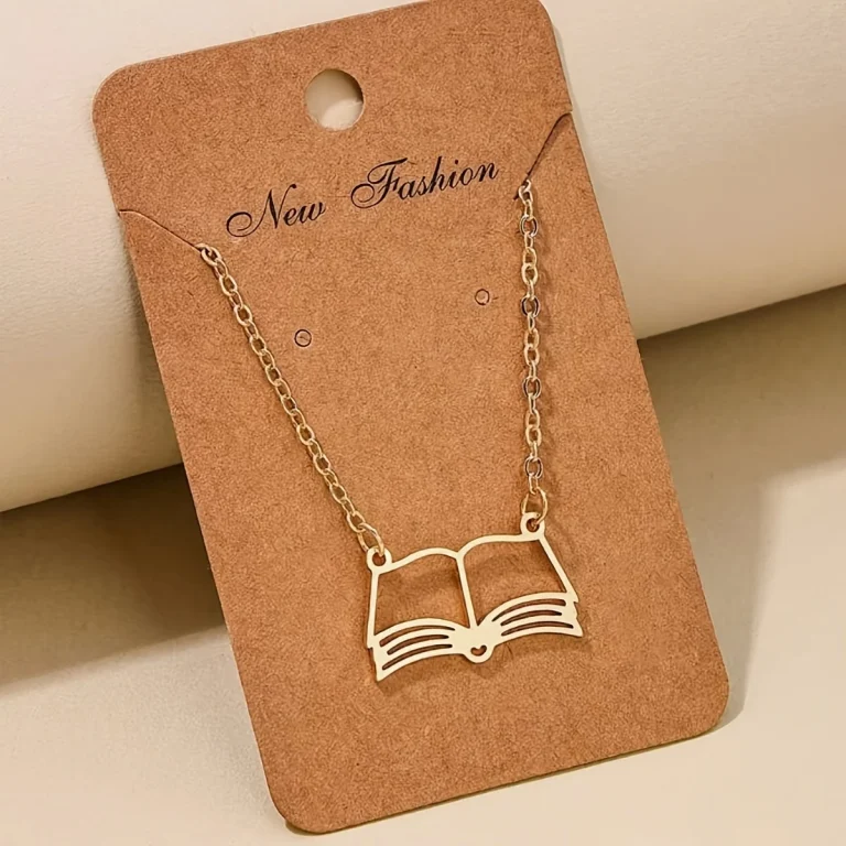 Gold-tone open book pendant necklace on display card
