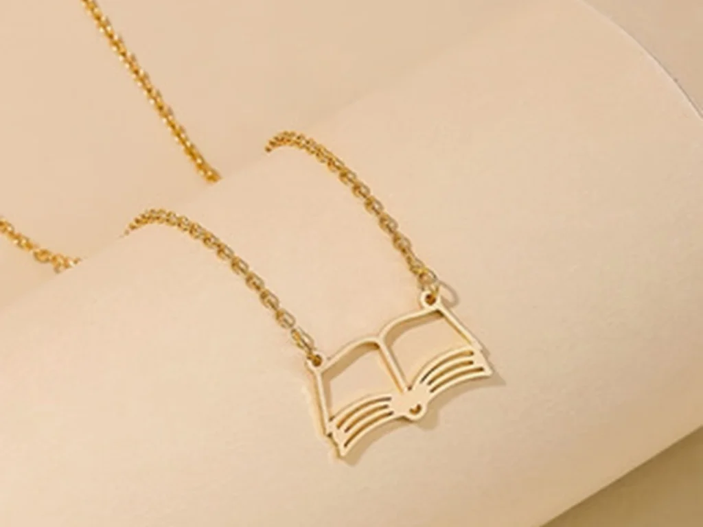 Gold-tone open book pendant necklace close detail view