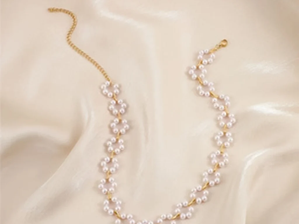 Pearl floral choker necklace product arrangement on silk
