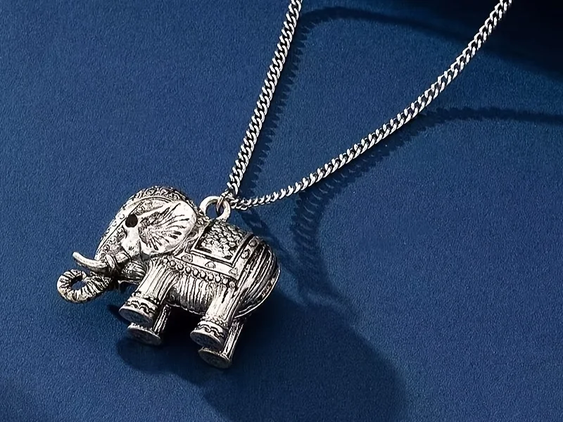 Elephant-shaped pendant with raised decorative details and a chain connection