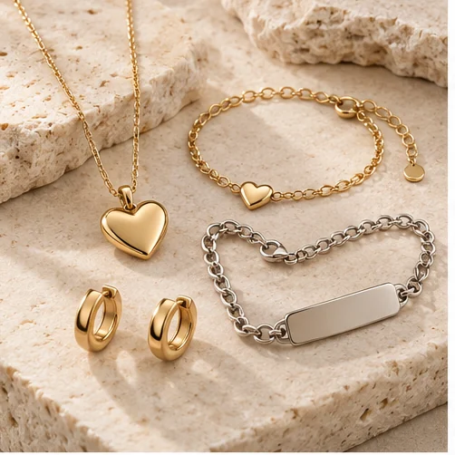 Age-defined product direction: ring, earrings, necklace and bracelet on warm stone