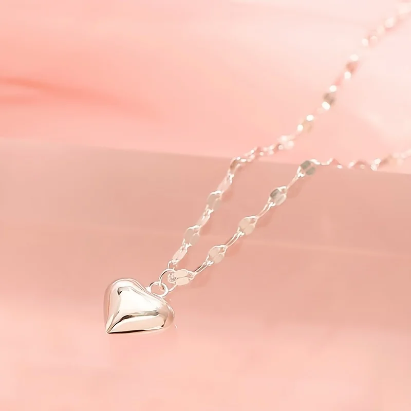 Silver-tone heart pendant attached to a linked chain by connecting rings