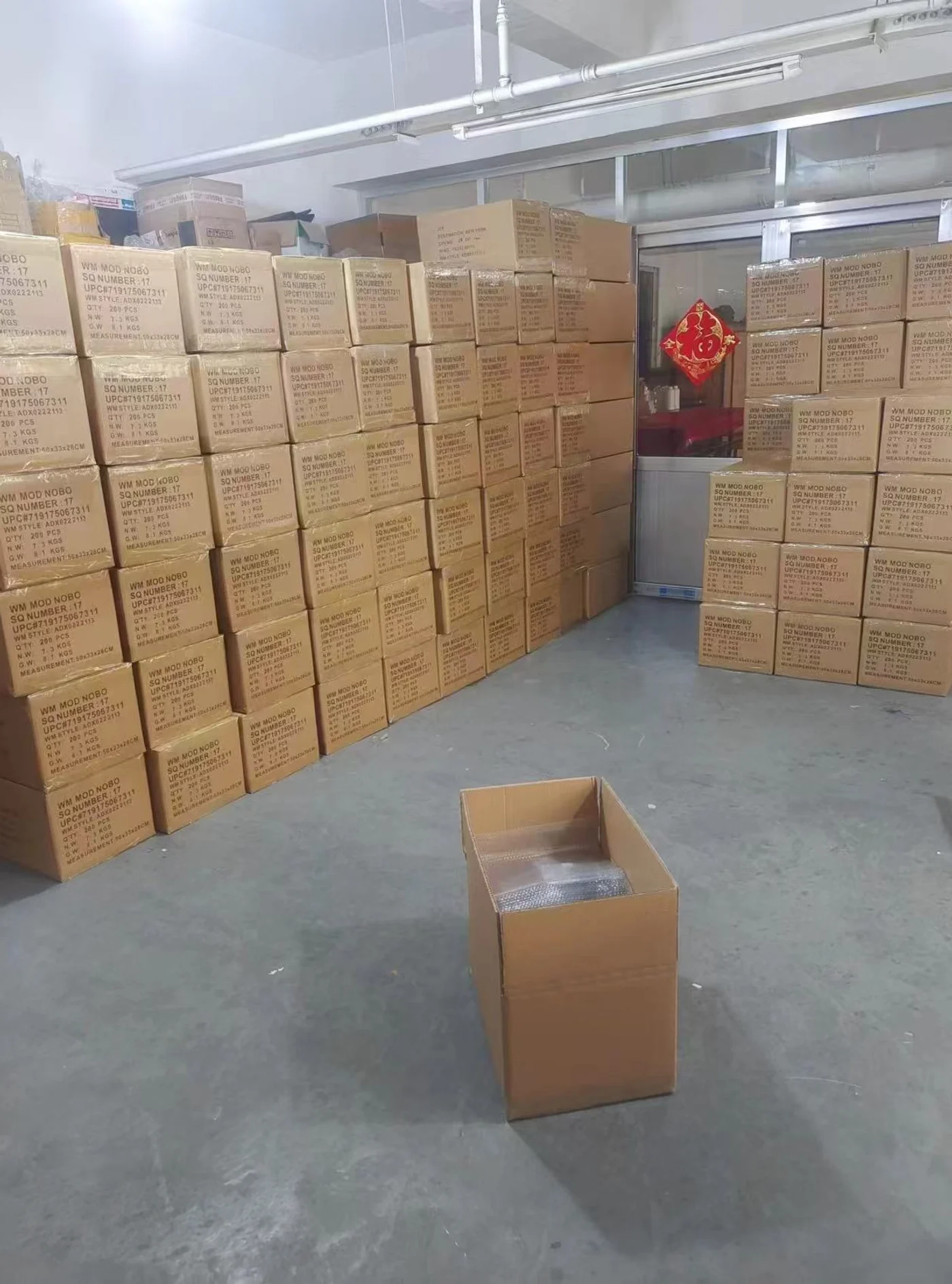 Cardboard cartons stacked beside an aisle in a storage room